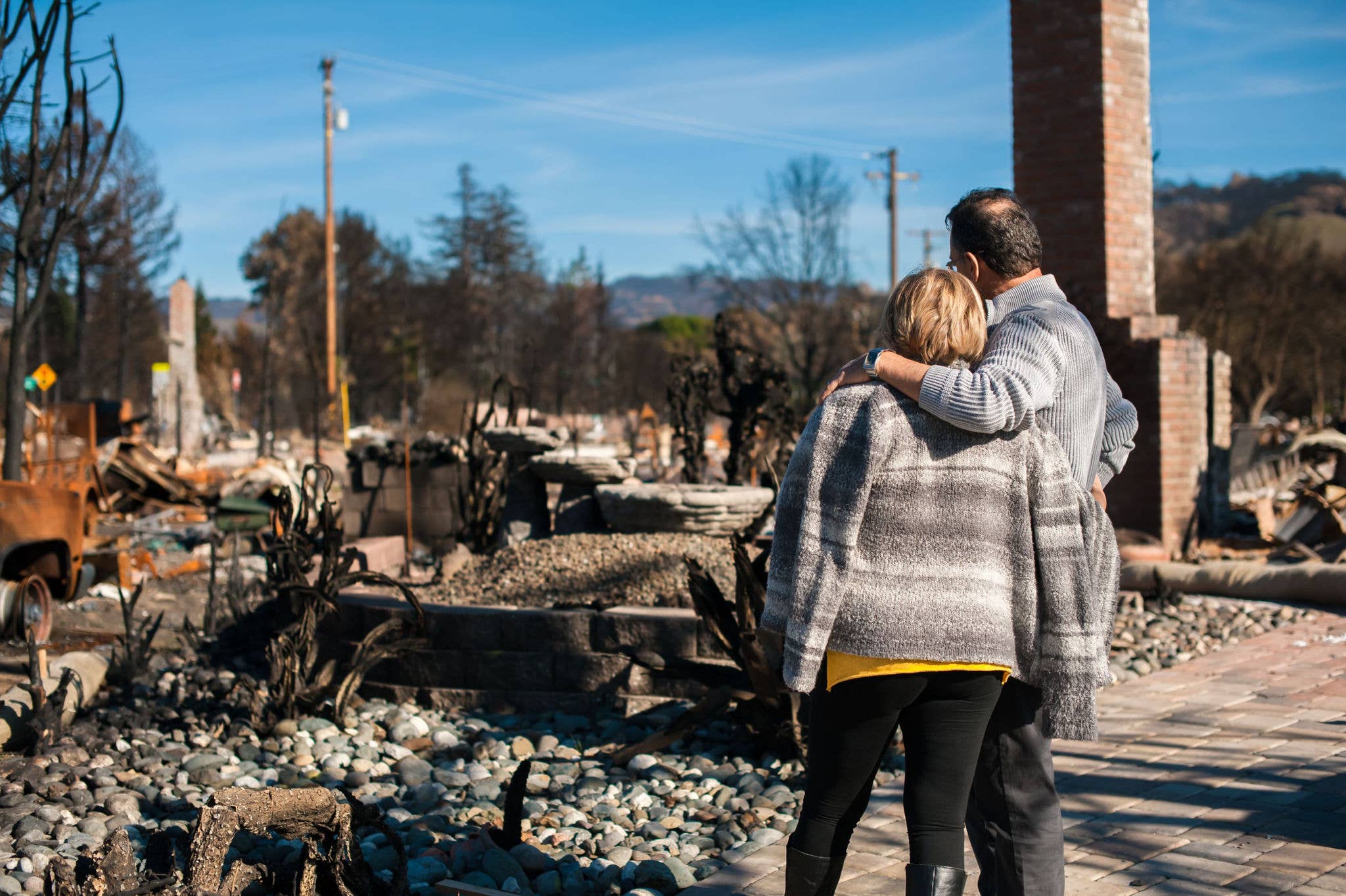 Couple looking at house that's burnt down