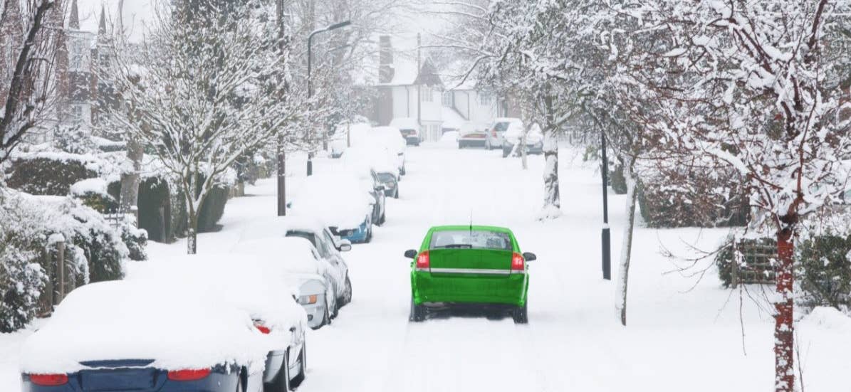 car driving down snowy street