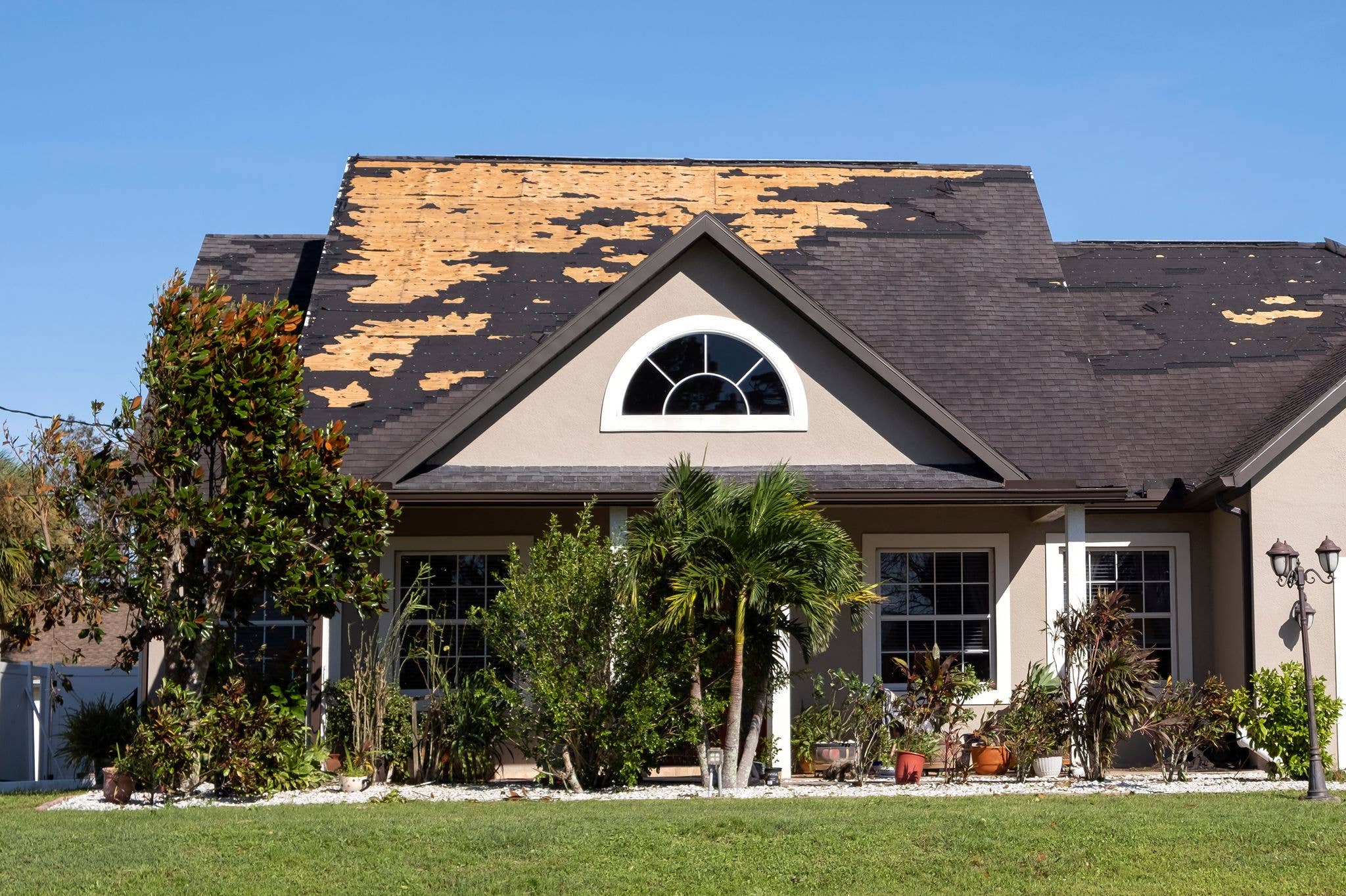 A house with severe roof damage after a storm.