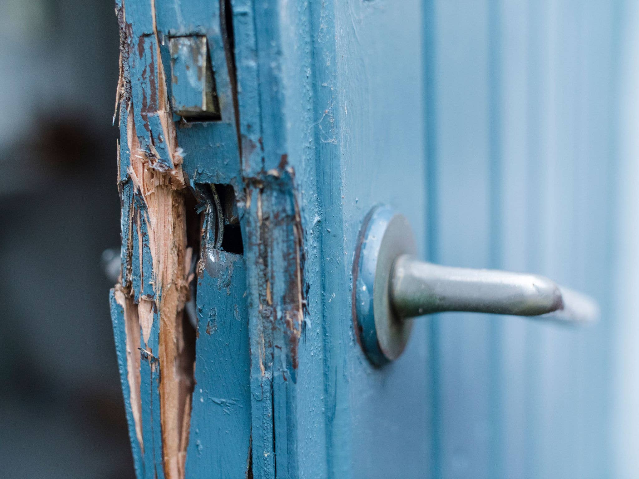 Blue door broken from someone breaking into home