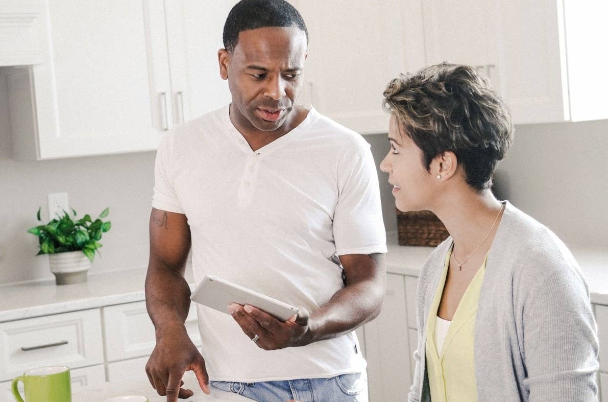 Man and woman looking at tablet in kitchen